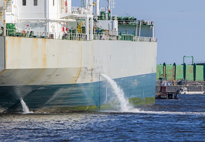Tanker discharging ballast into the harbor. Water flows from the
